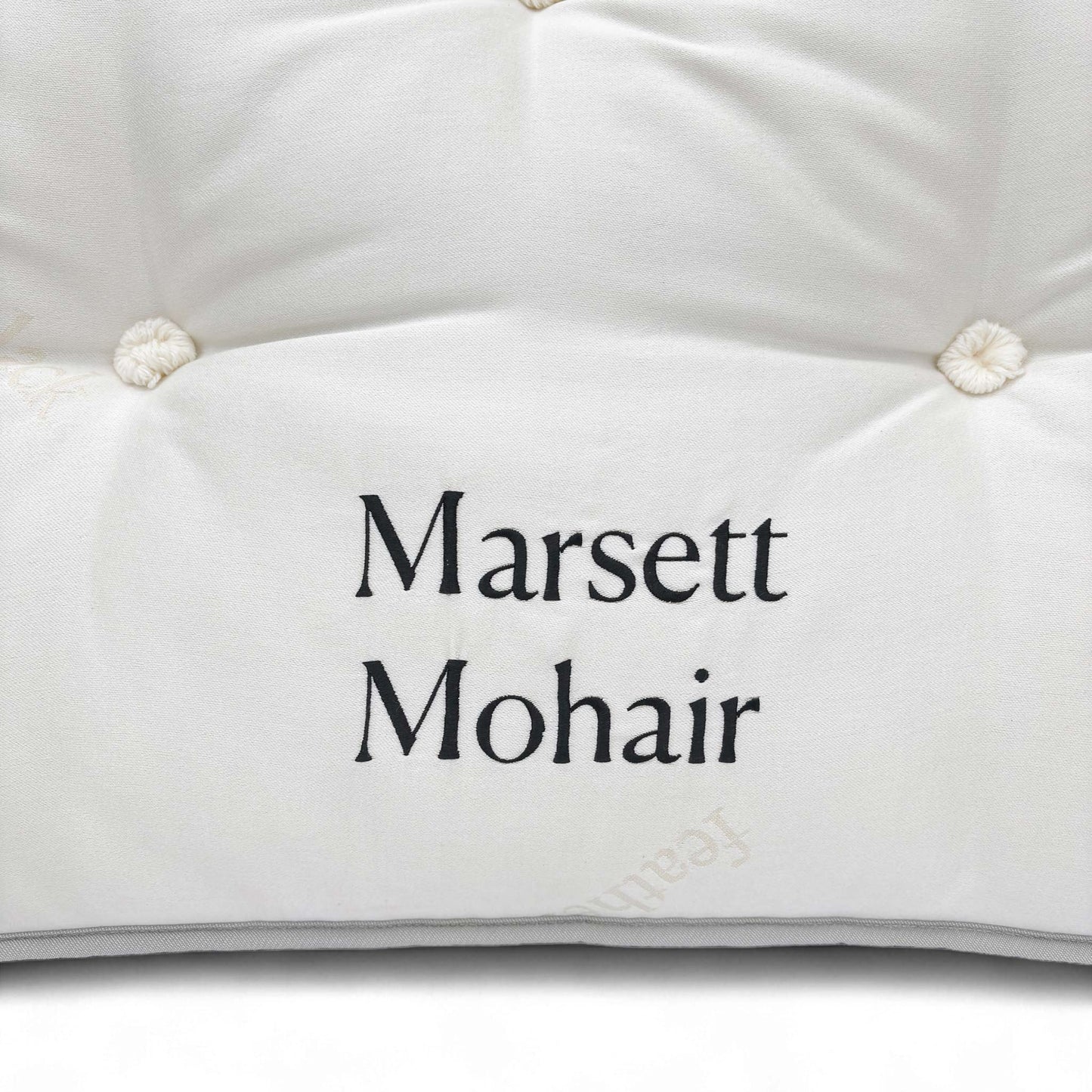 Angled close-up of the surface texture and tufting.