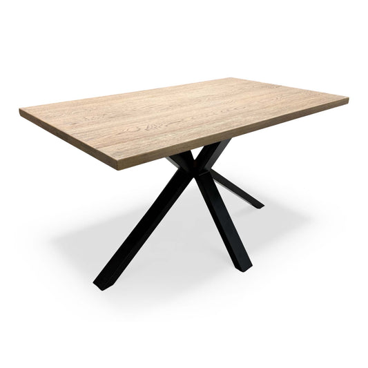 'Saturn' Solid Oak Compact 135cm Fixed Dining Table, angled view on a white background showing the cross-shaped black metal legs