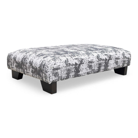 The ‘Aura’ Kai Grey Designer Footstool upholstered in soft chenille fabric, featuring a modern low-profile design and dark wood feet.