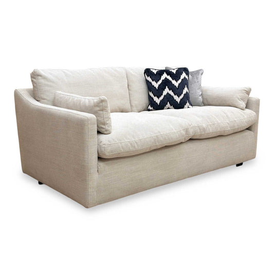 Full view of Nick Scali Dream 2 seater sofa upholstered in soft natural fabric with a streamlined silhouette.
