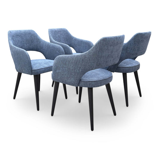 Full view of the ‘Manu’ navy blue fabric fixed dining chairs in a set of 4 with black metal legs.