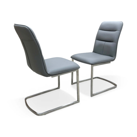 Full view of Pair of 'Cashmere' dining chairs in charcoal grey faux leather featuring modern stainless steel cantilever bases.