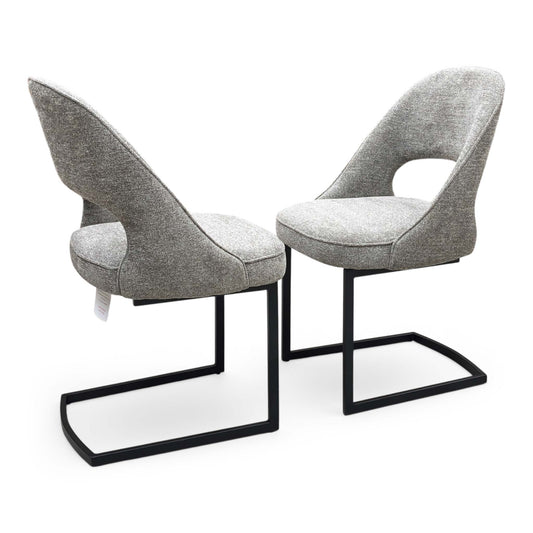 Full view of a pair of ‘Tiber’ Cantilever Dining Chairs in Truffle Brown fabric, showcasing their sleek contemporary C-shaped frames, vertical channel-stitched backs, and minimalist industrial profile.
