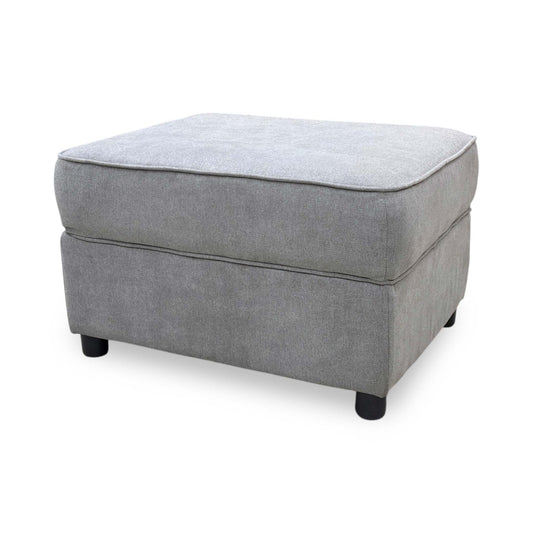 Full view of the Comfi storage footstool in light grey fabric, showcasing its modern rectangular design, deep button tufting, and plush padded top cushion.