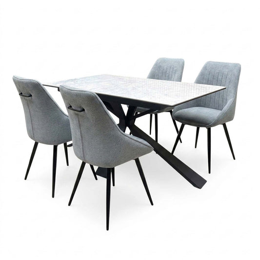 Crete ceramic top 180cm extending dining table with four dark grey fabric swivel chairs, angled from the left