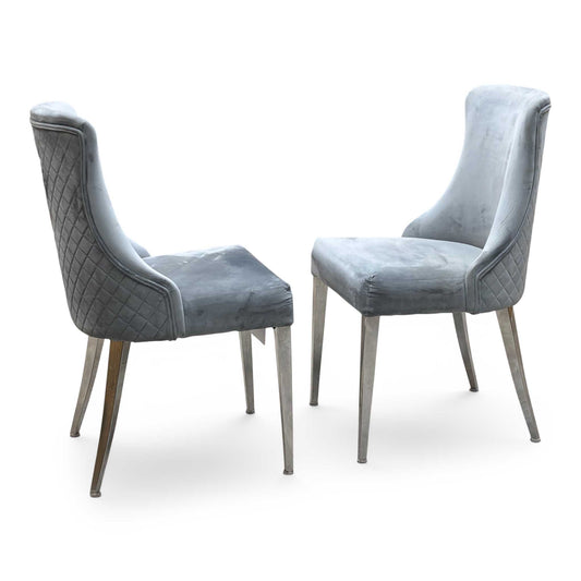 Full View ‘Dolce’ contemporary dining chair set, showcasing a pair of luxurious chairs beautifully upholstered in a rich Silver fabric with sleek modern legs.