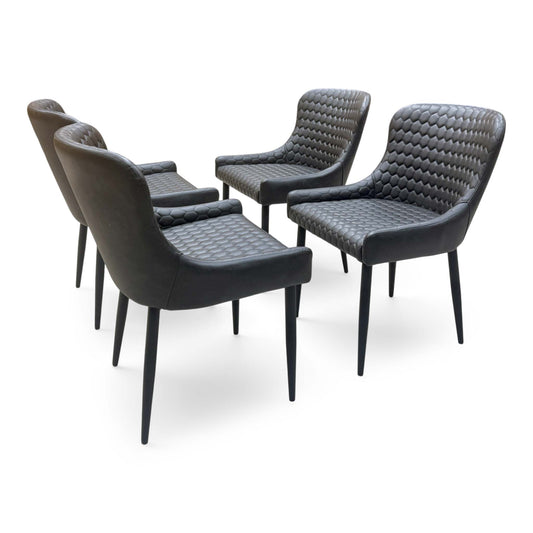 Set of 4 Osaka black faux leather dining chairs with honeycomb-stitched backs, angled from the left