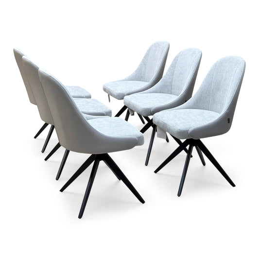 Jose stone grey faux leather swivel dining chairs, set of six with fabric seat pads, angled from the left