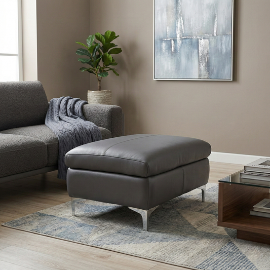 Living room view of the Vino footstool, showcasing the soft Lavender Grey leather texture and the high-quality tailored finish.