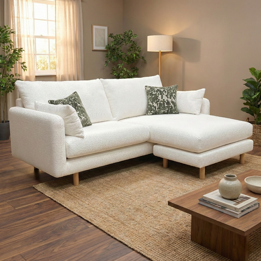Living room shot of the ivory boucle lounger in a bright living room setting, showcasing the reversible chaise.