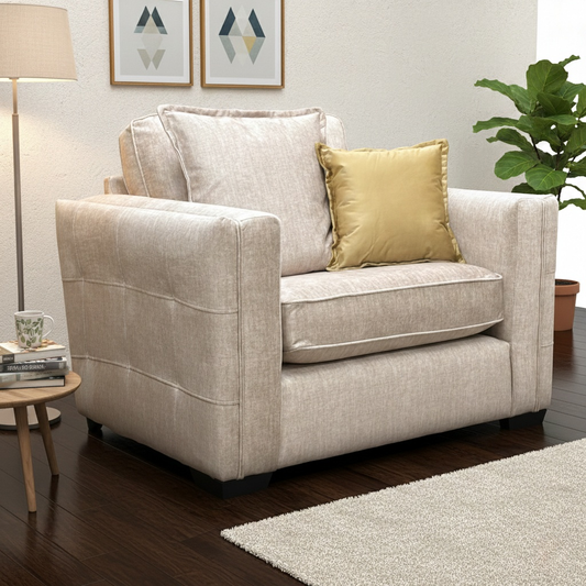 Living Room view of the beige velvet snuggler chair, highlighting its wide seat and compact silhouette.
