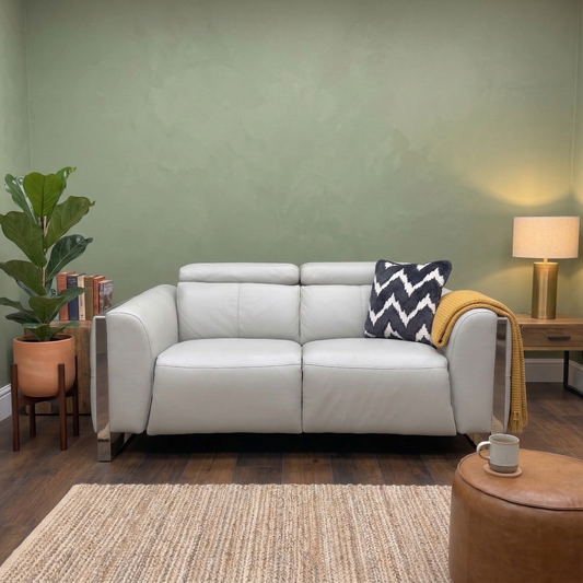 Living room view of the light grey leather sofa showcasing the premium characterful leather texture and modern geometric stitching.
