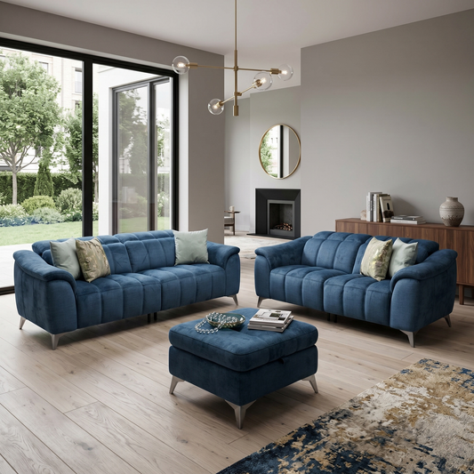 Living room view of three-quarter angled view of the Angelo Giula dark blue fabric 3-seater couch, highlighting its deep-seated pocket spring cushions, fluted detailing, and black chrome-effect metal legs.