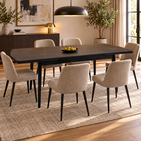 Magda black oak extending dining table in a dining room with six beige fabric chairs and a bowl of pears