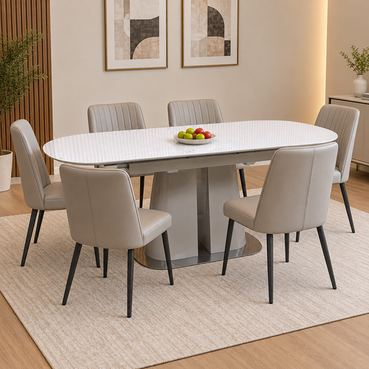 Cashmere white glass top extending dining table in a dining room with six grey chairs and a bowl of apples