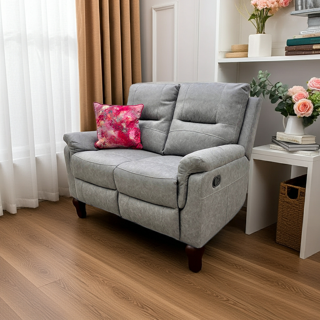 Gray recliner sofa with a pink floral pillow in a living room setting.