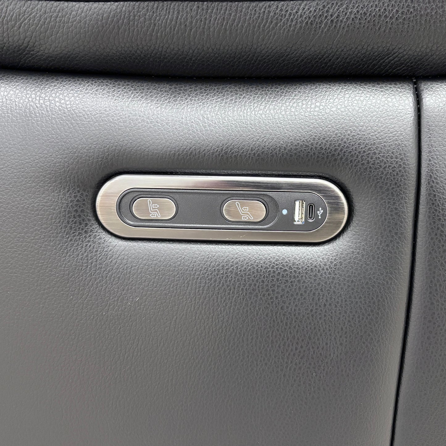 Close-up showing the controls for the power recliner mechanism, including the USB charging port located on the armrest.