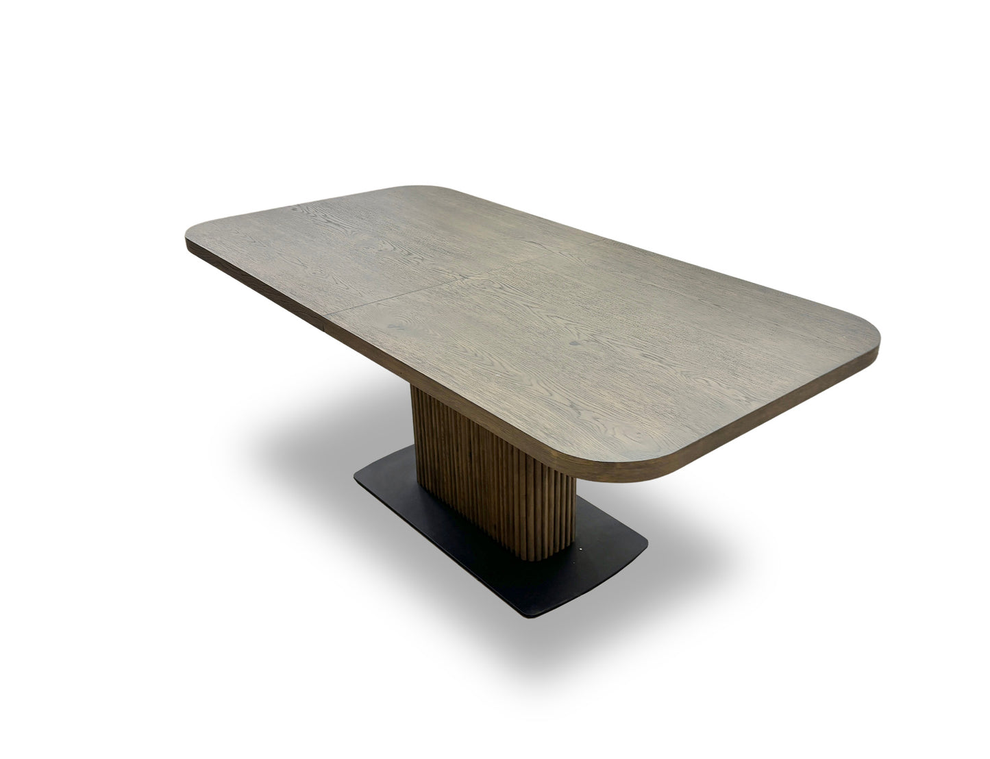 Close-up detail of the Jai dining table's pedestal base, featuring vertical linear grooves and a square black metal plinth at the bottom.