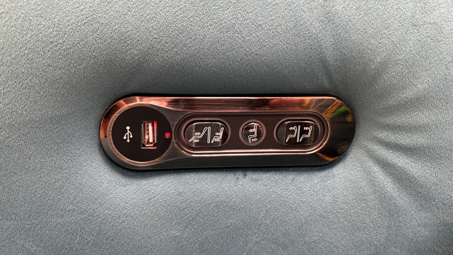 Close-up view of the side-mounted control panel on the 'Cora' chair, showing the buttons for the power recliner and headrest adjustments.
