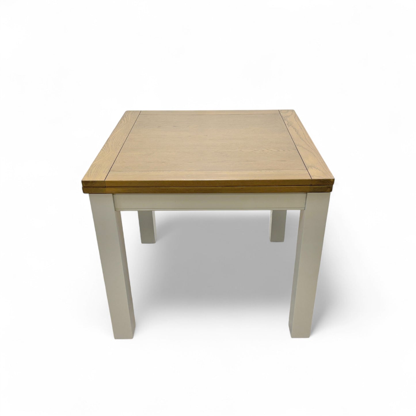 Close-up of the tabletop of the 'Hamilton' dining table in its compact, square position, highlighting the natural grain and knot markings of the American Oak wood.