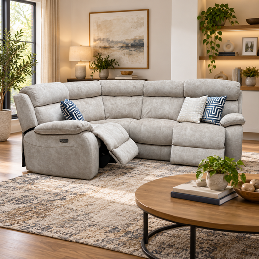 Moreno cream velvet power recliner corner sofa in a living room, one seat reclined, with a round wooden coffee table