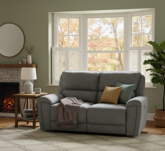 Gray sofa in a living room with a fireplace and large window