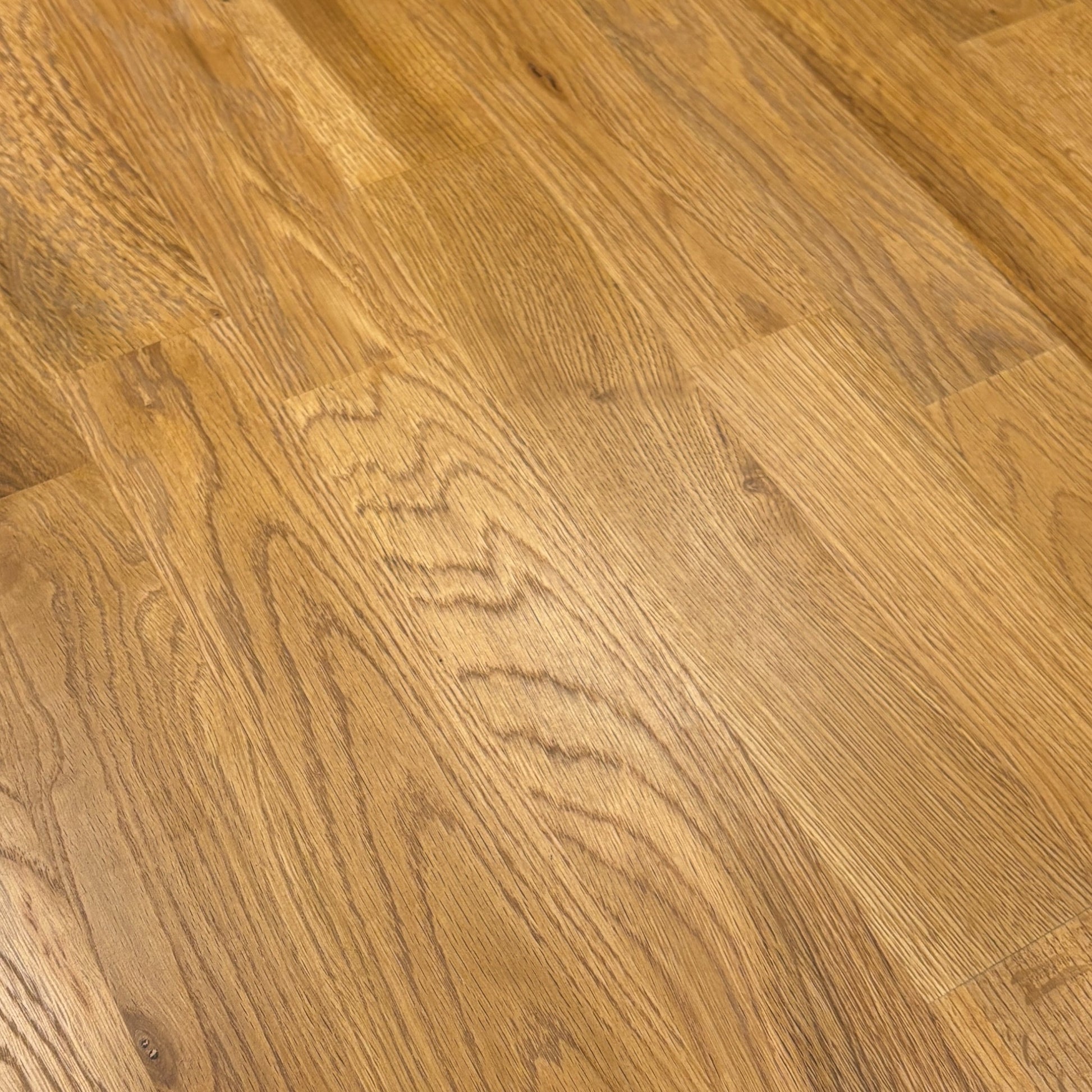 Close-up detail of the smooth, solid oak tabletop of the 'Bakerloo' Dining Table, revealing the natural wood grain and texture.