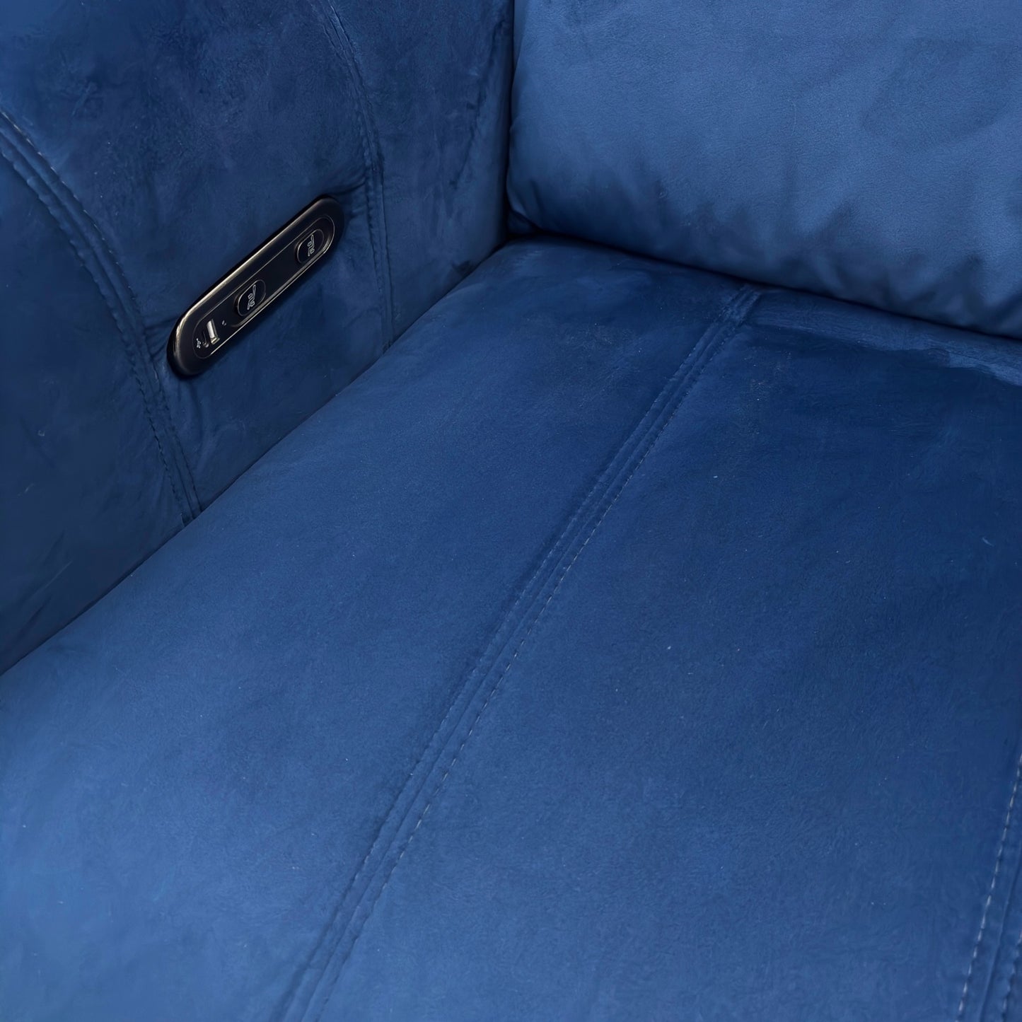 Close-up view of the power recliner footrest in the fully extended position, showing the metallic base and stitching detail.
