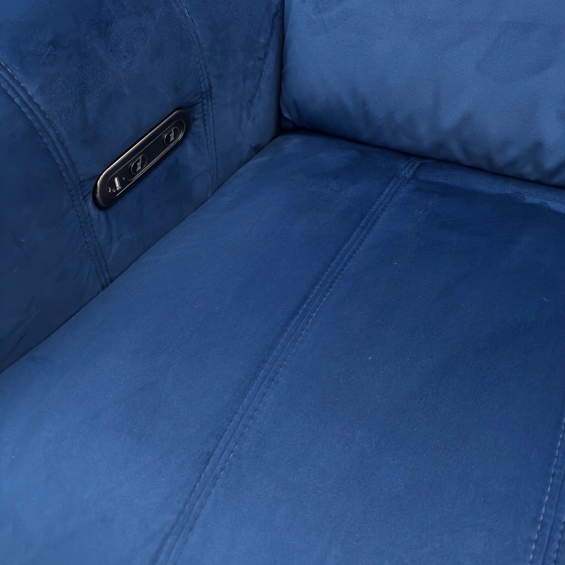 Close-up view of the power recliner footrest in the fully extended position, showing the metallic base and stitching detail.