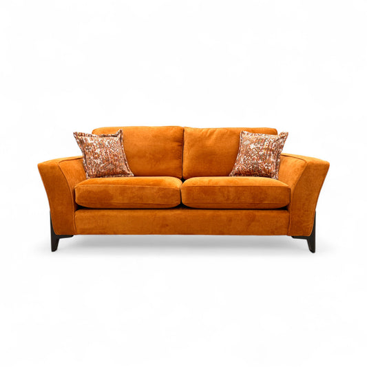 Front-on view of the plush 'Collins' Almond Orange Towel Velvet 3 Seater Sofa, emphasizing its solid color and contemporary design.