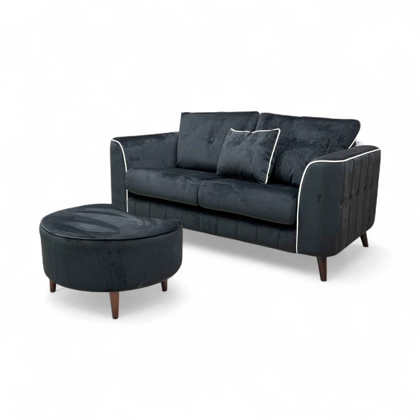 An image showing the overall modern profile of the sofa and footstool, emphasizing the size and sloped armrests.