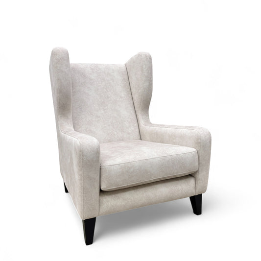 Full view of the 'Dolcie' wing chair in cream combination velvet, featuring a high backrest and scrolled arms.