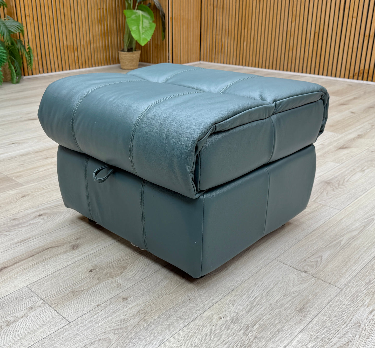 High-angle shot of the closed footstool, showing the generous surface area and the precision of the leather stitching.