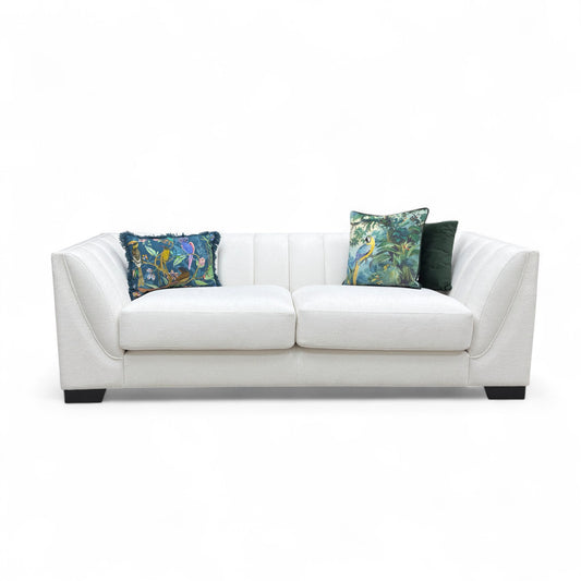 White sofa with floral-patterned cushions on a white background