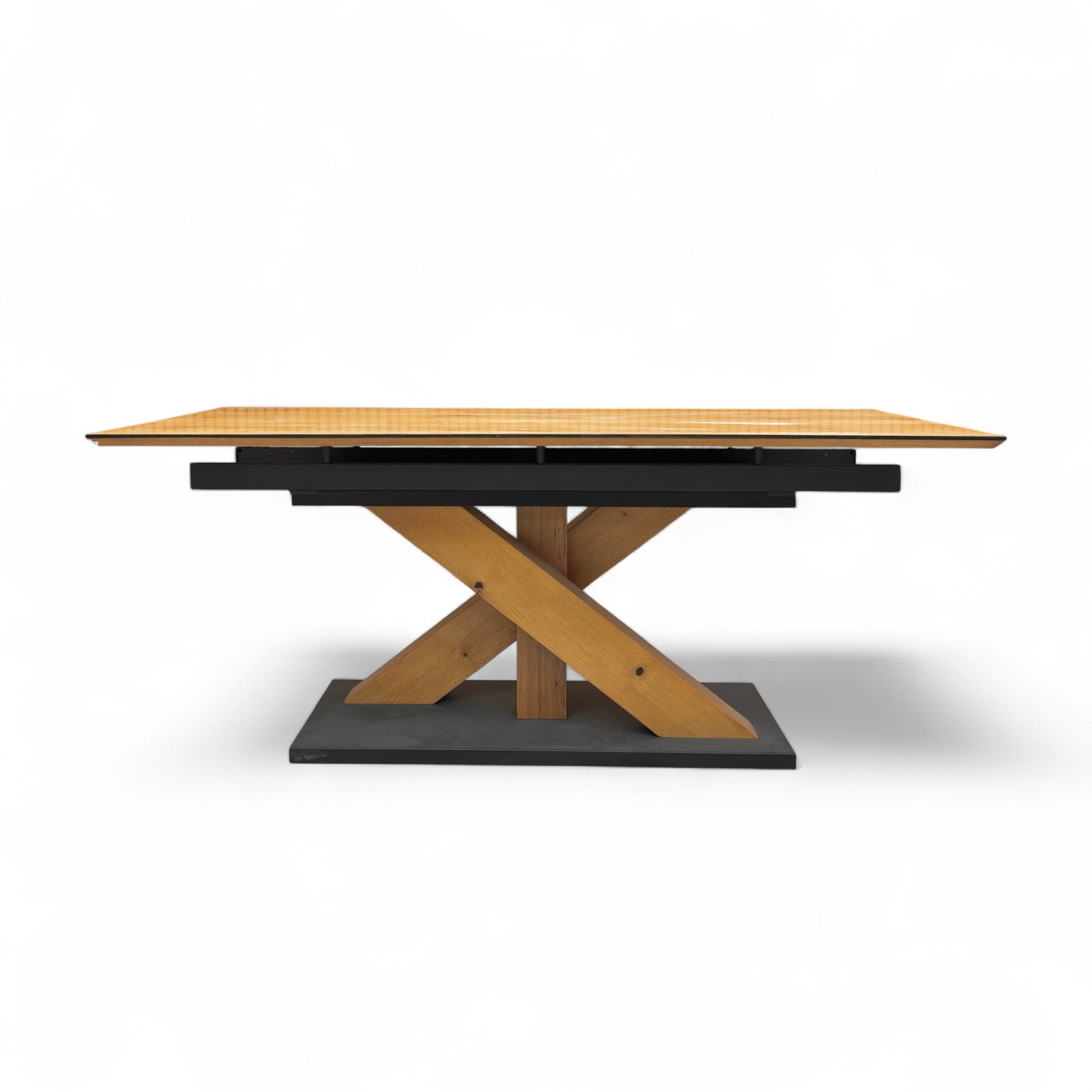 Wooden dining table with a black base on a white background