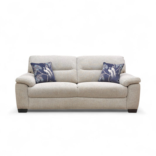 Beige sofa with blue pillows on a white background