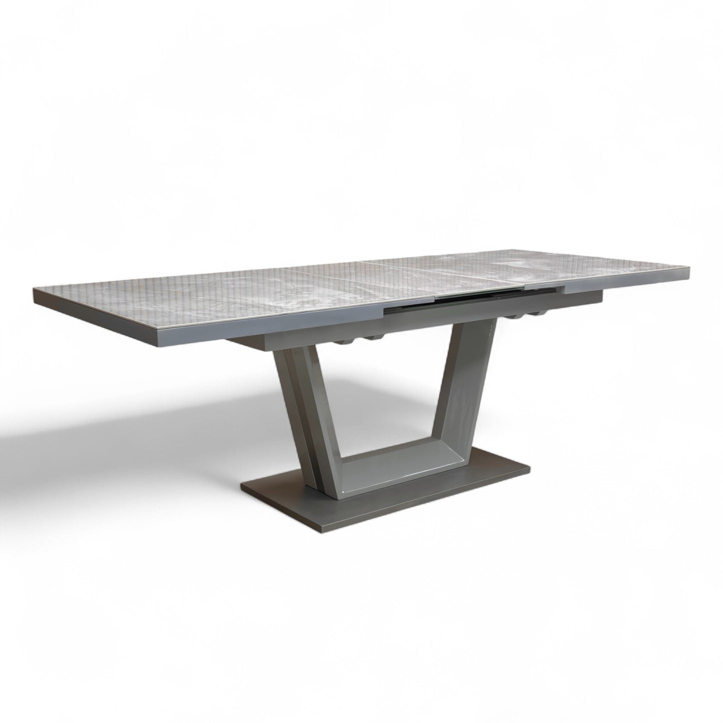 Shot focusing on the brushed stainless steel U-shaped pedestal base and plinth of the Grigio extending table.