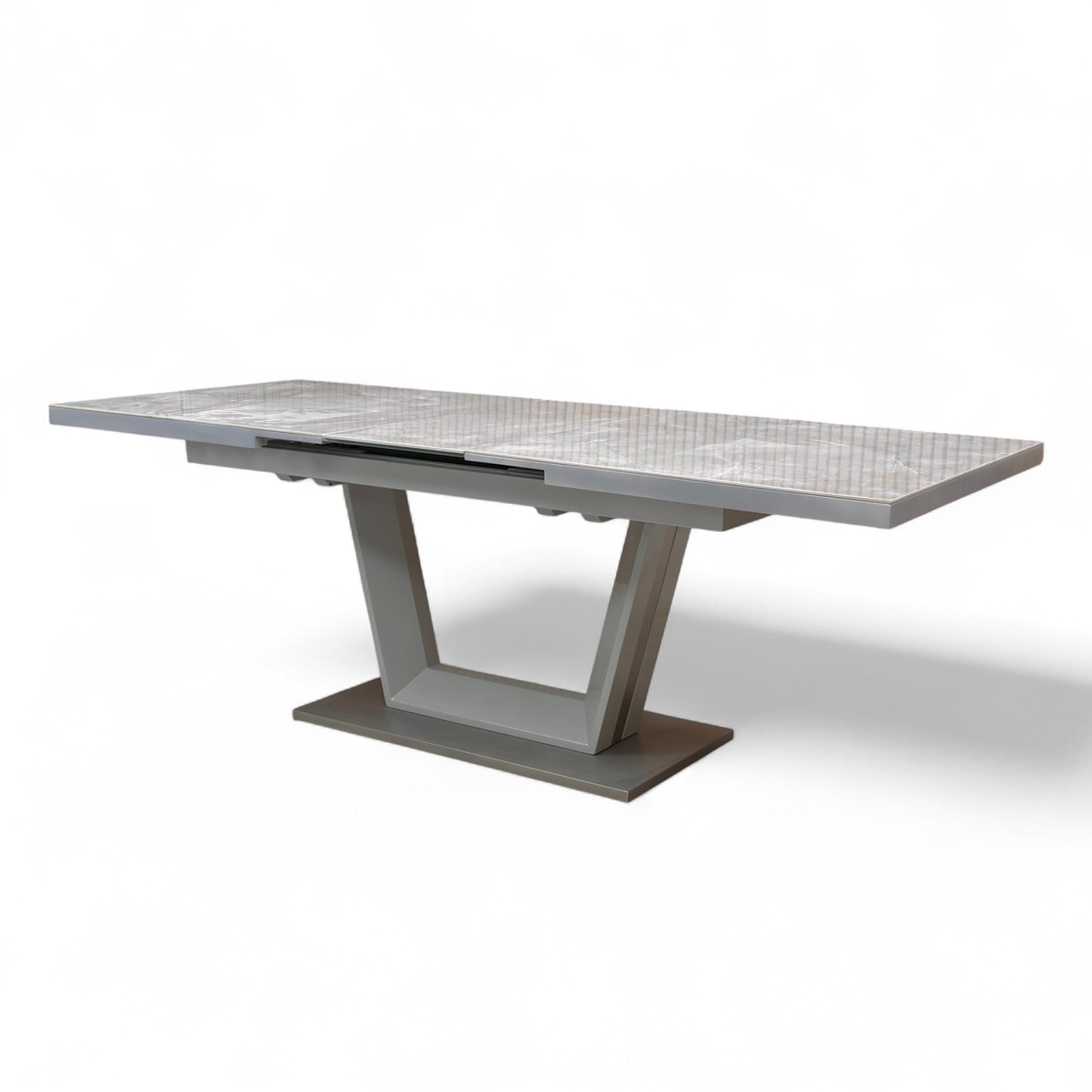 Detail showing the smooth transition and seamless look of the marble-effect ceramic top when the extension leaf is deployed.