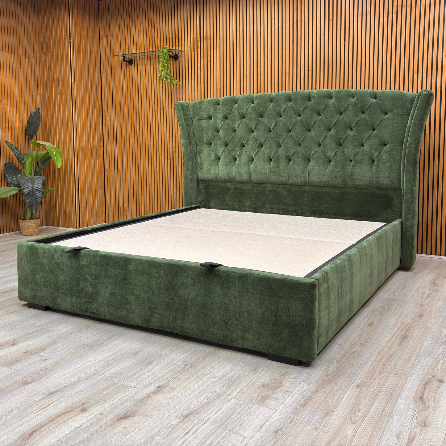 Lifestyle image of the Super King-size 'Dorian' bed in a bedroom, demonstrating its substantial size and the rich color of the moss fabric.