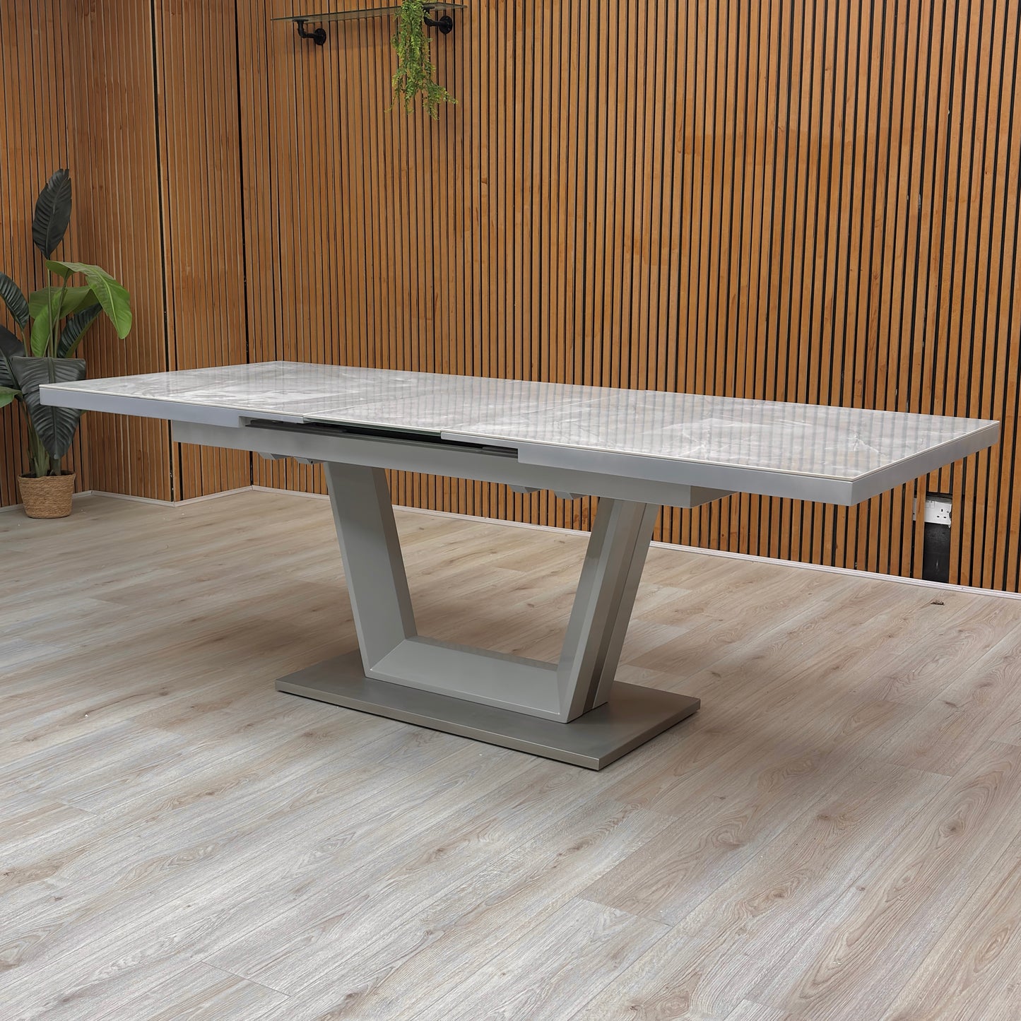 Lifestyle image of the 'Grigio' Extending Dining Table paired with contemporary chairs, showing its scale and elegance in a dining setting.