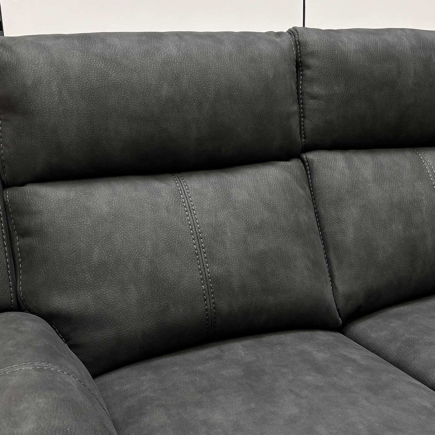 Close-up of the manual recliner pull-latch located on the side of the 2-seater leather sofa.
