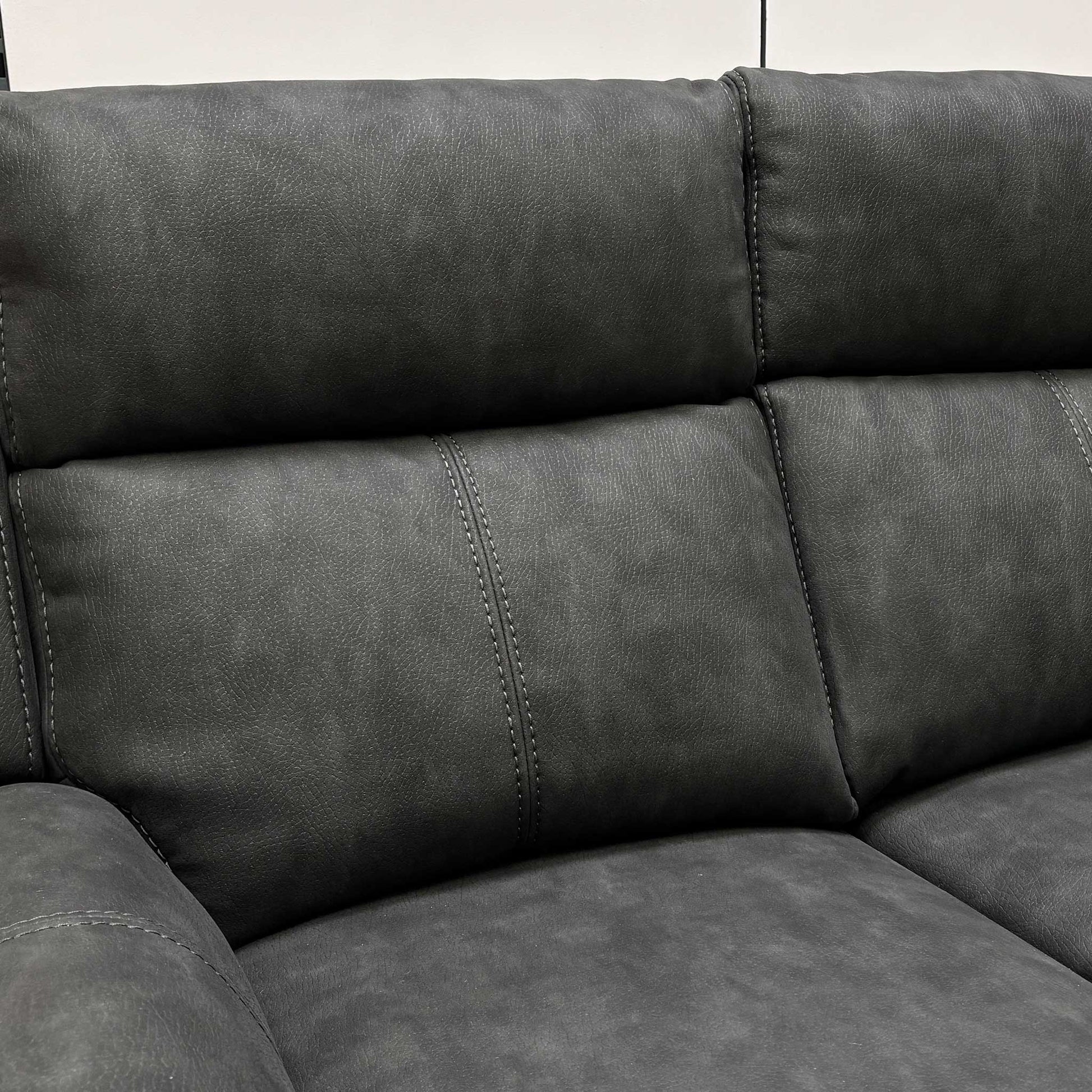 Close-up of the manual recliner pull-latch located on the side of the 2-seater leather sofa.