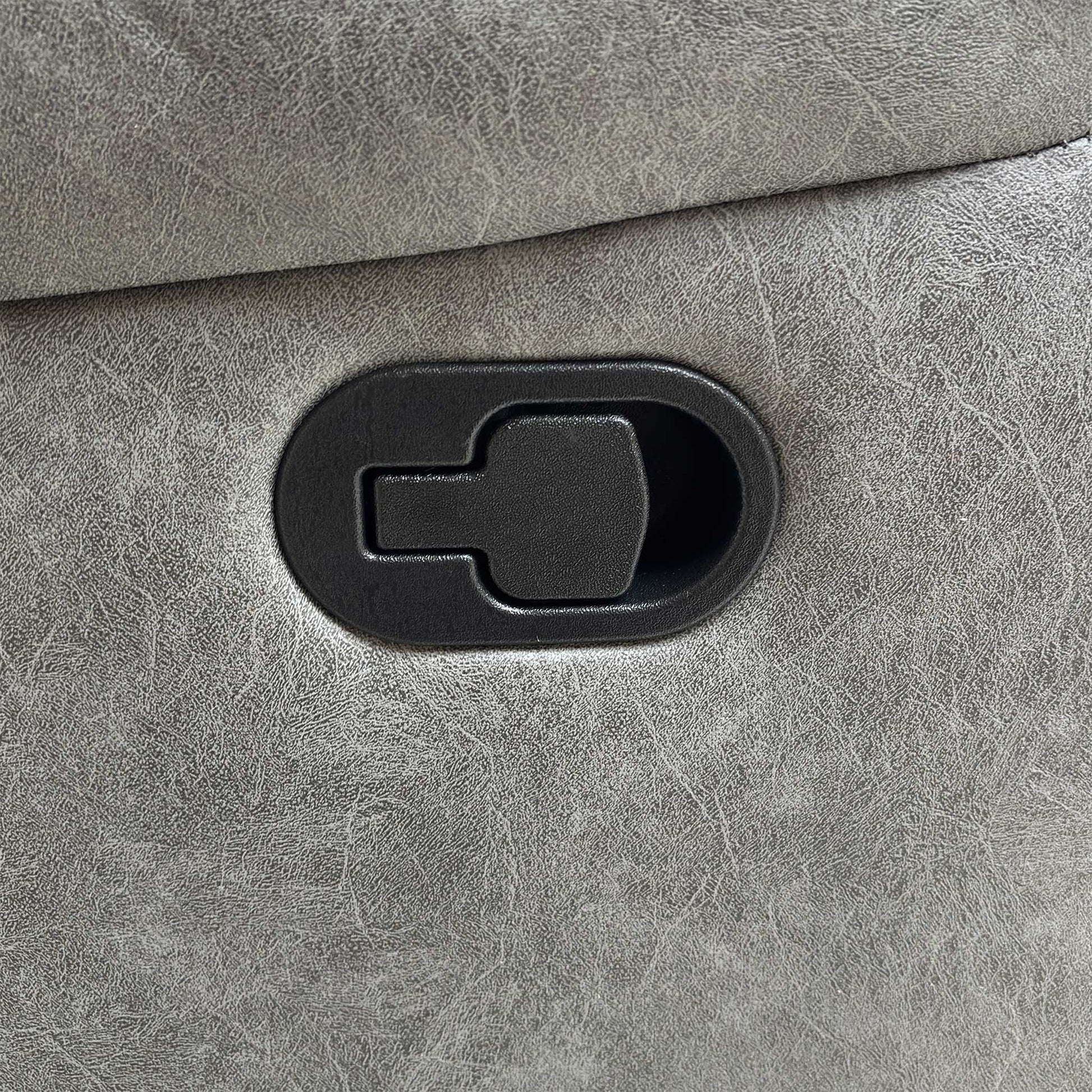 Detail shot of the black manual handle or latch used to operate the footrest and recliner mechanism on the side of the sofa.