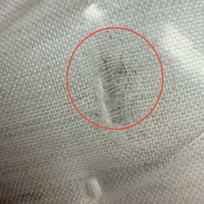 A detailed close-up of the mattress side border showing a visible scuff mark and slight surface soiling on the dark grey fabric near the chrome air vent.