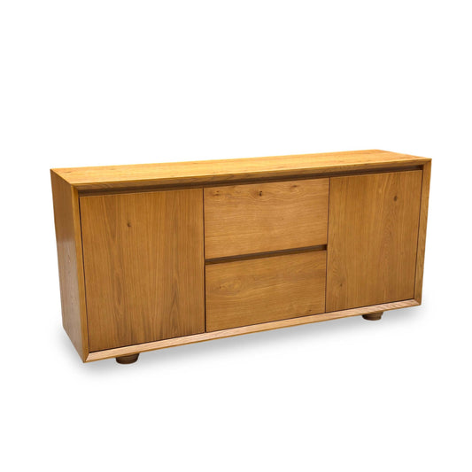 Full view of the Aydin sideboard in a warm oak veneer, showcasing its symmetrical design featuring 2 central drawers flanked by 2 spacious side doors.