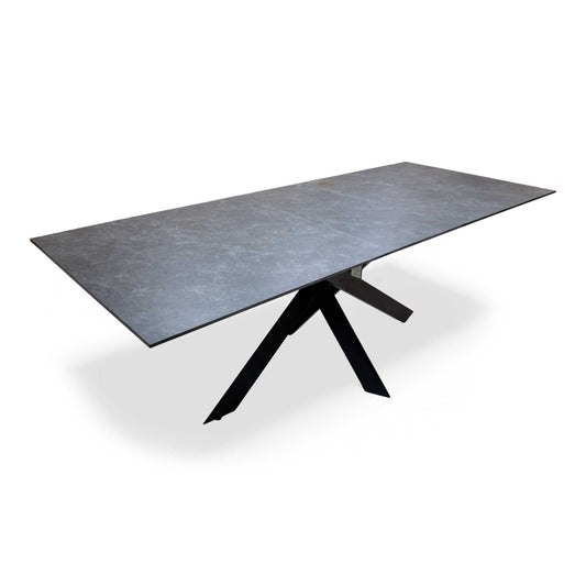 Full view of the 'Warrior' Grey Sintered Stone Dining Table in its 180cm closed position, showcasing the stone top and metal legs.