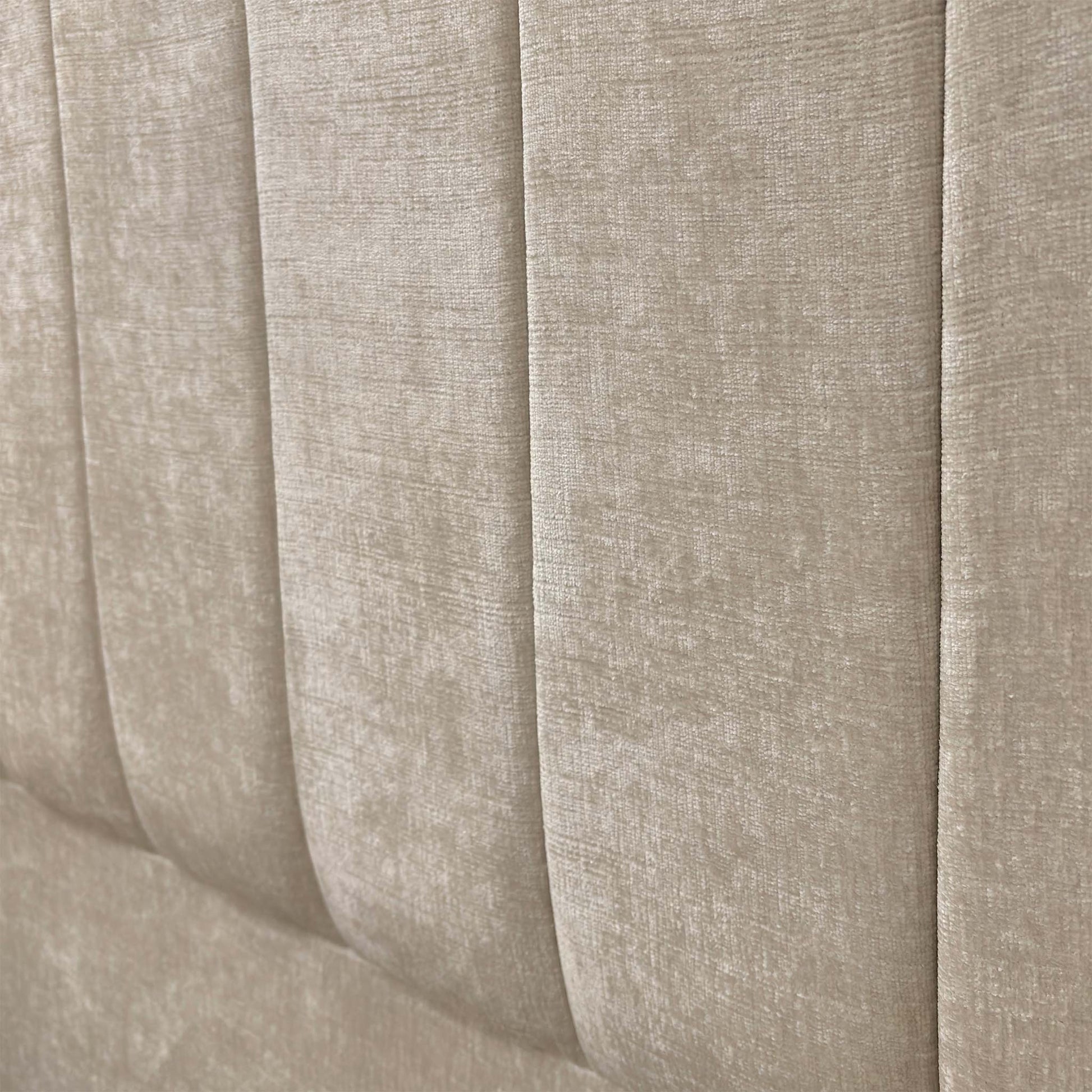 Close-up shot detailing the texture of the Kashmir Chalk fabric and the contemporary vertical fluting on the Miranda headboard.
