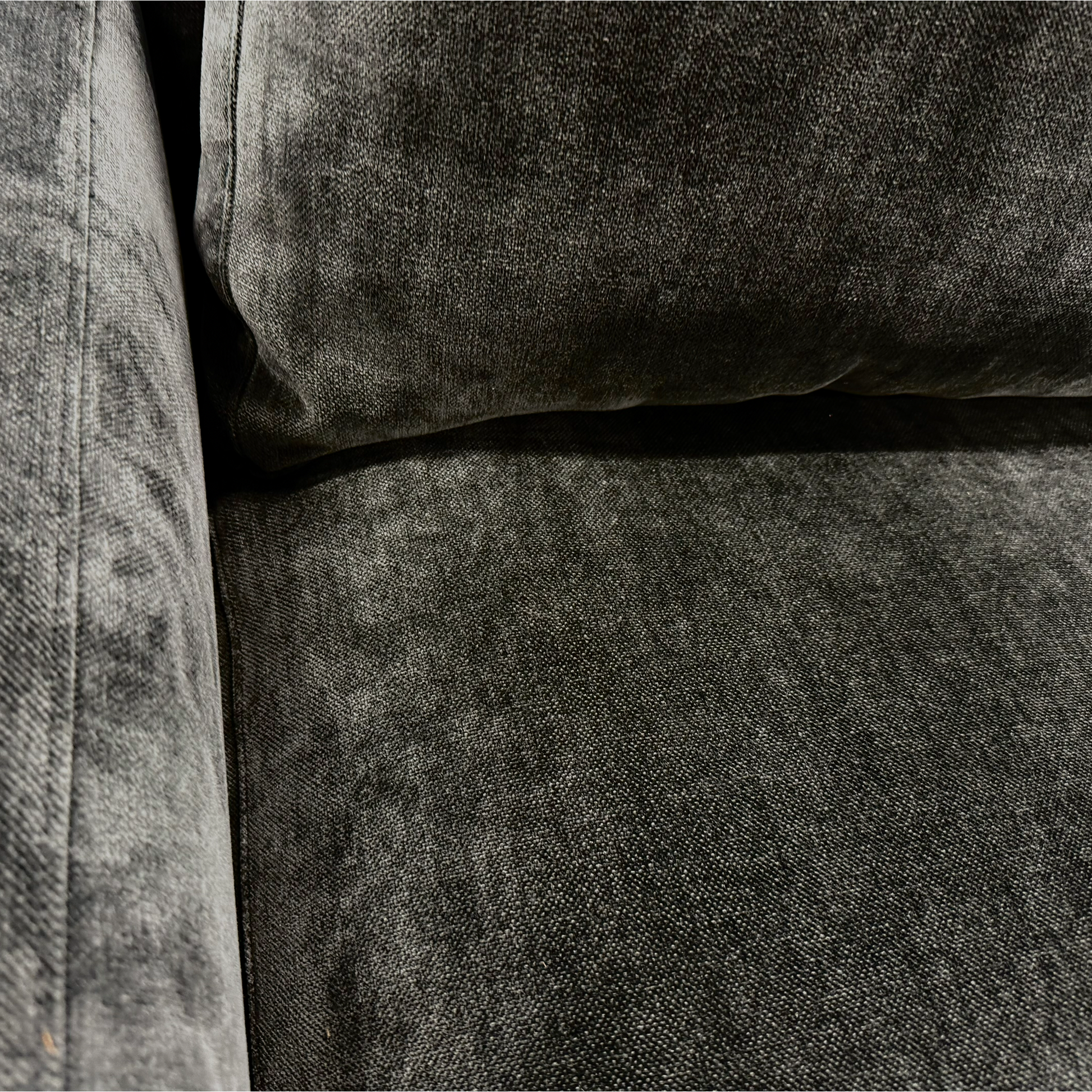 Angled close-up of the Swoon 'Denver' sofa, highlighting the texture of the charcoal grey linen fabric and the shape of the armrest.