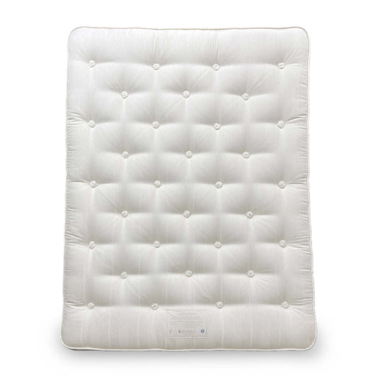 Angled view of the Hypnos Extra Firm King Mattress, showing the deep tufted white top and side stitching.