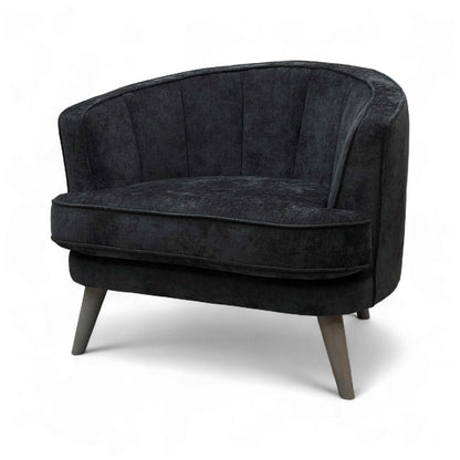 A view of the chair from a low angle, emphasizing the elegant tapered legs and the foam cushioning.